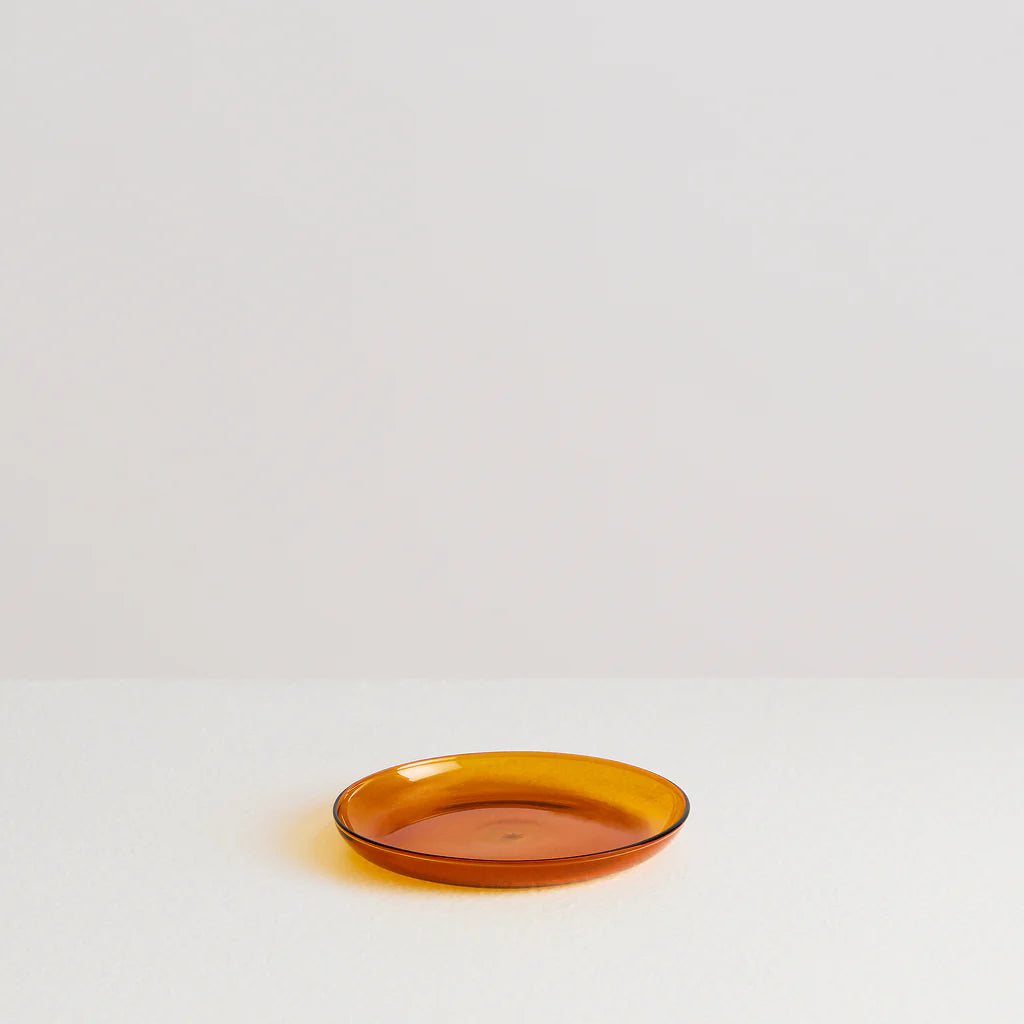 An amber coloured glass plate on a white background