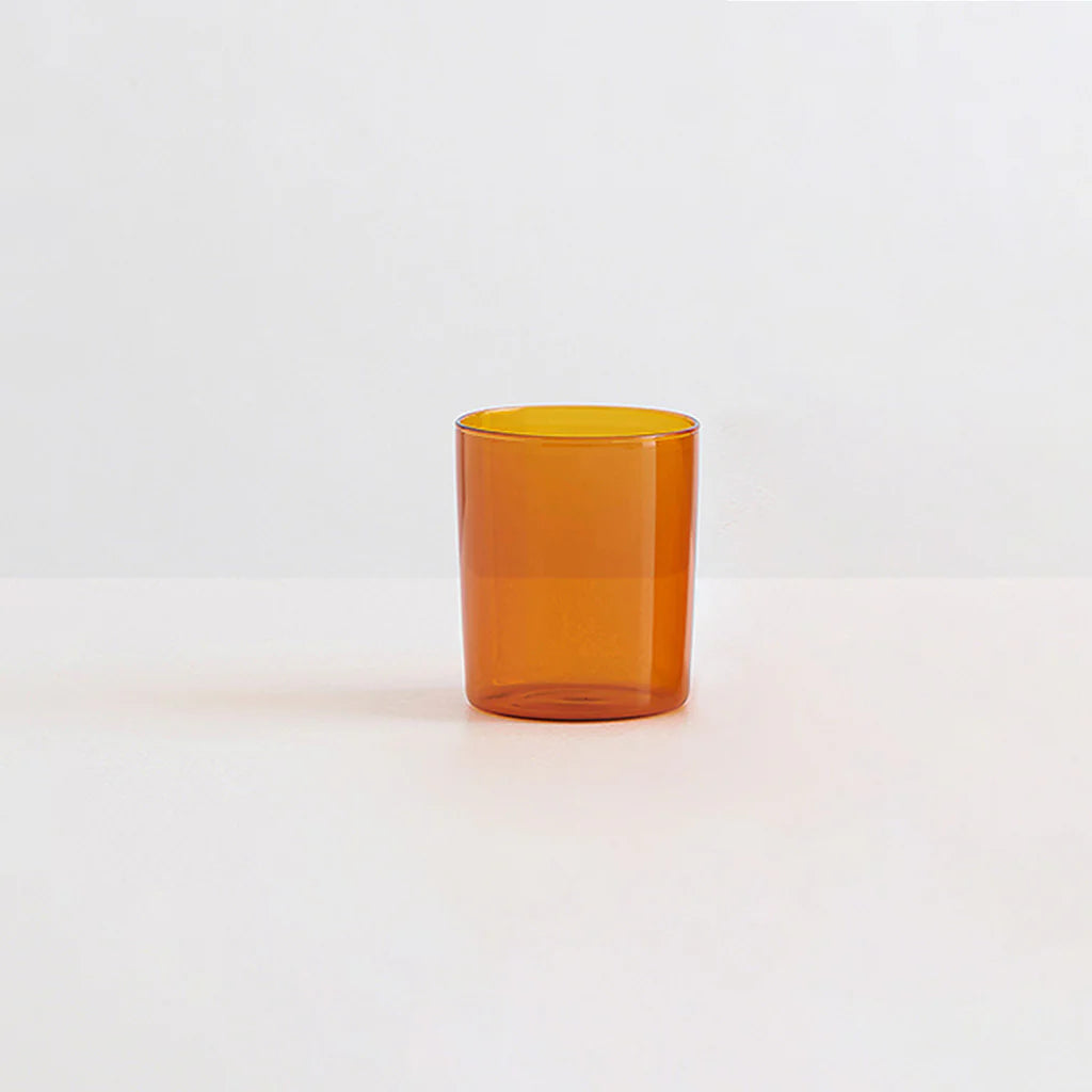A clear amber drinking glass on a white background