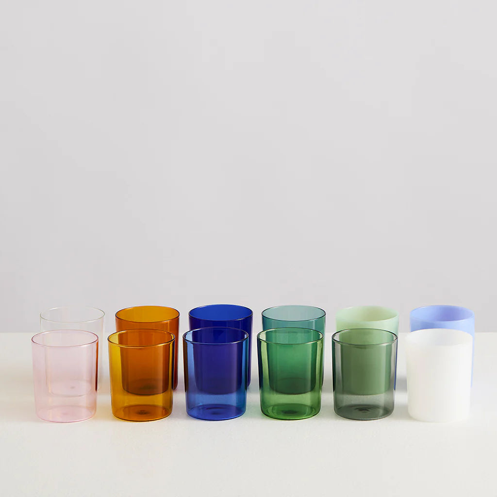 A selection of clear and opaque drinking glasses in varying colours