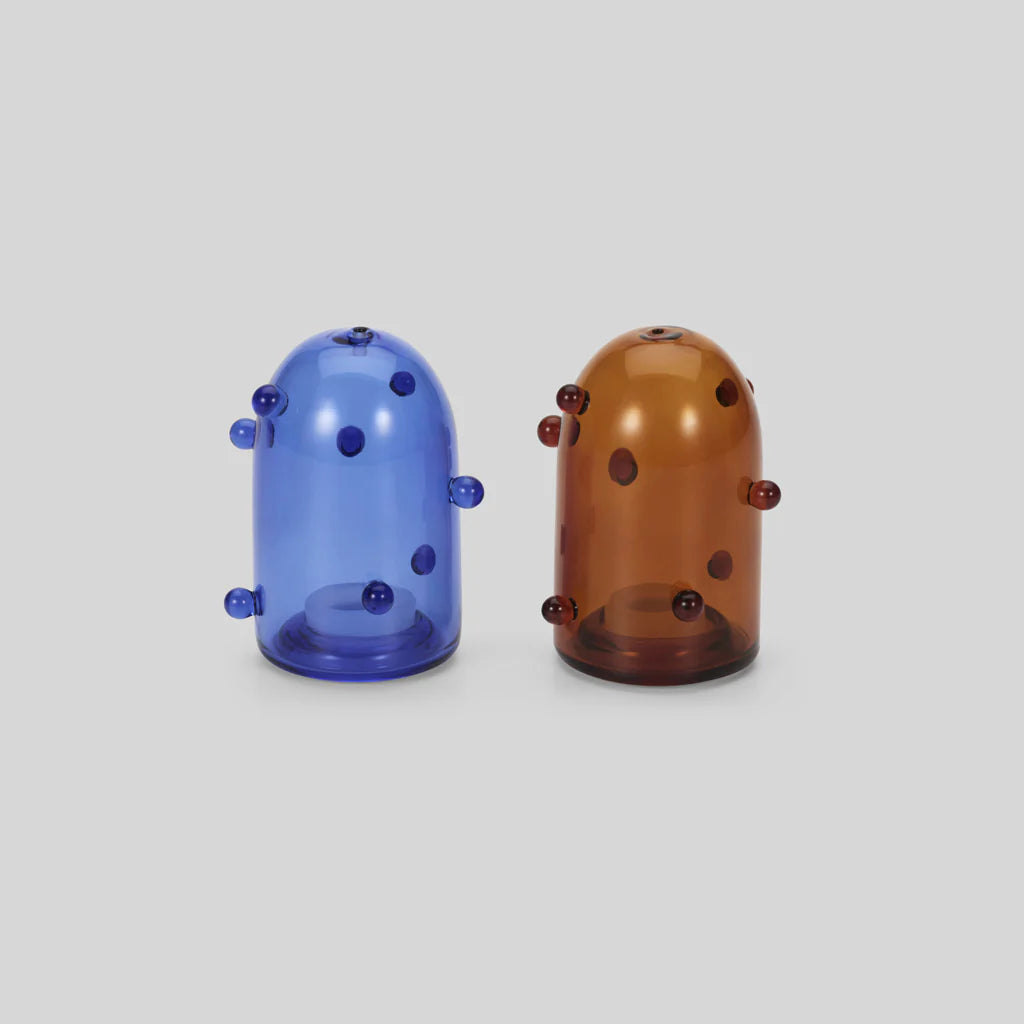 Two clear glass salt and pepper shakers with little bauble details. One is blue and one is amber coloured.
