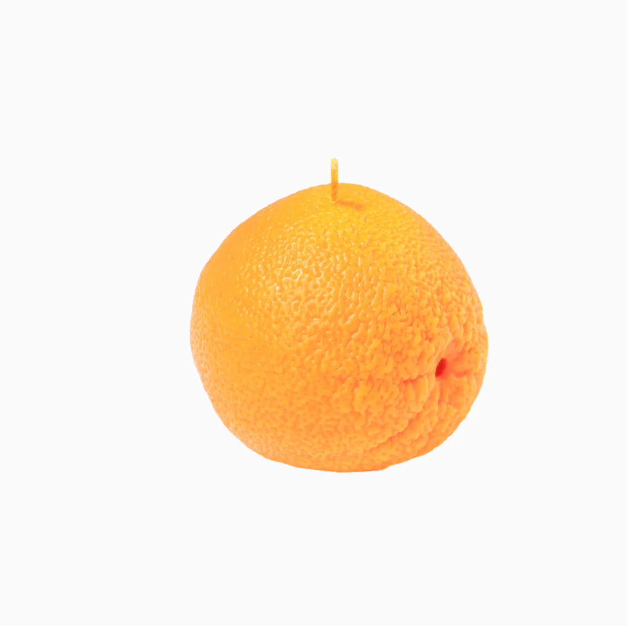 An orange shaped candle on a white background